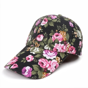 Detailed view of pink rose floral print on black canvas fabric of a sun visor baseball cap