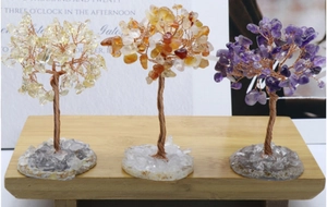 Detailed view of three wire-wrapped crystal trees on an agate base for home decor