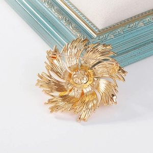 Elegant gold fireworks brooch with radiant petal texture on a vintage blue background