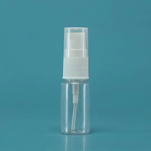 Close-up of clear refillable plastic spray bottle with white pump head on blue background