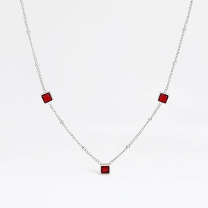 Détail du collier en acier inoxydable argenté avec trois zircons rouges de forme carrée