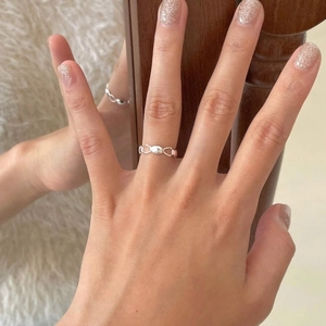 Minimalist 925 sterling silver wave ring for women shown on hand with mirror reflection