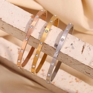 Detailed view of stacked 18K gold and silver plated bangles with cubic zirconia stones