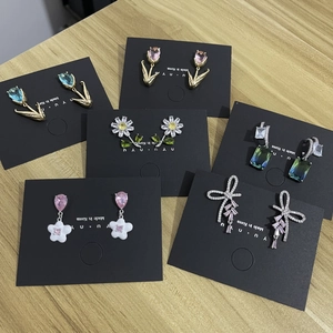 Detail shot of elegant floral and gemstone earrings displayed on jewelry cards