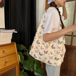 Detailed view of cream canvas tote bag featuring vibrant butterfly embroidery and frayed edges
