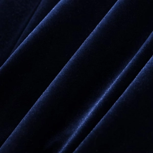 Macro shot of dark blue velvet fabric texture with soft natural sheen and pleats