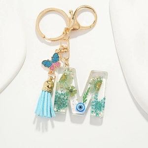 Resin letter M keychain with dried flowers, blue tassel and golden butterfly charm