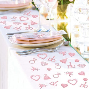 Pink glitter wedding confetti with heart, ring, and I DO shapes on white table cloth