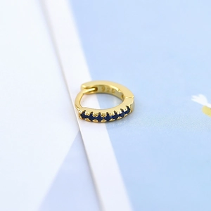 Macro detail of a 925 sterling silver hallmark on a gold-plated blue zircon hoop earring