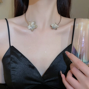 Close-up of silver metal flower choker necklace on collarbone for elegant evening styling