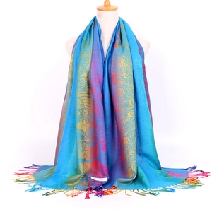 Detail of colorful peacock feather jacquard pattern and fringes on long scarf shawl