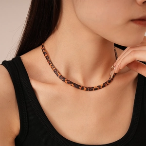 Detailed view of leopard print herringbone snake chain necklace on model neck
