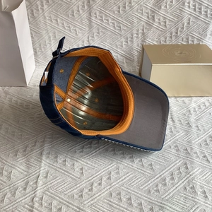 Detailed inner view of blue denim baseball cap featuring orange seam tape and rhinestones