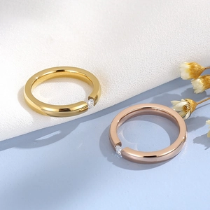 Detail of minimalist gold and rose gold stainless steel rings with zircon settings