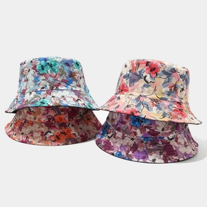 Detail of four colorful watercolor floral bucket hats with reinforced stitching on the brim