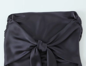 Détail du tissu en satin gris foncé montrant le grand nœud décoratif et la texture