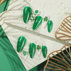 Green and white St. Patrick's Day almond press-on nails with shamrock patterns and glitter