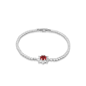 Macro detail of silver floral tennis bracelet featuring central red zircon and white stones