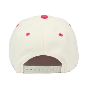 Detail view of beige trucker hat featuring pink top button and adjustable snapback closure