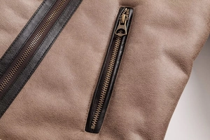 Macro shot of bronze zipper and brown faux suede texture on a vintage jacket