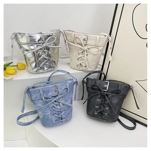 Vue détaillée de quatre sacs seaux à nœuds en argent, beige, bleu denim et noir