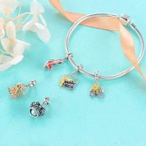 Silver charm bracelet featuring a red high heel, crown, and Happy Easter pendant charms
