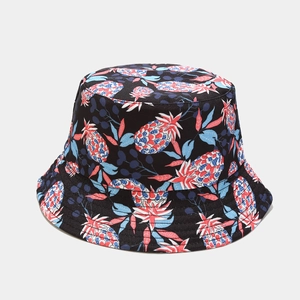 Close-up of tropical pineapple print on black reversible bucket hat with durable stitching