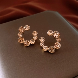 Détail macro de boucles d'oreilles en cristal champagne avec tiges en argent sur cuir