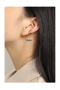 Detail view of 13mm gold minimalist hoop earrings and ear cuff on a model