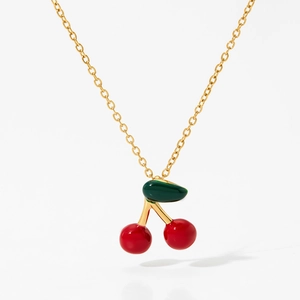 Detailed macro view of cherry pendant necklace with red enamel fruits and green leaf