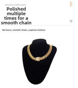 Polished gold cuban link chain with textured square clasp on black velvet neck display