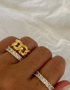 Close-up of stacked 18K gold chain ring and dual square-cut crystal eternity bands