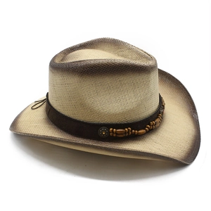 Detailed macro view of retro straw cowboy hat with brown gradient spray and wooden beads