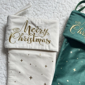 Detail of velvet Christmas stockings with gold embroidery on a soft plush background
