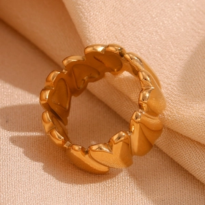 Macro shot of 18K gold plated stainless steel heart ring on soft beige silk background