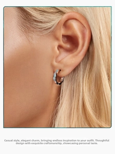 Close-up of wavy s925 silver earring with light blue enamel finish on model