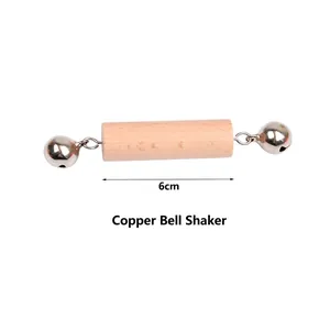Detailed view of wooden baby rattle with copper bells featuring 6cm handle dimensions