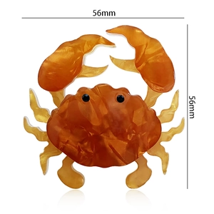 Macro detail of amber acrylic crab brooch with marble texture and dimensions 56x56mm