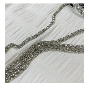 Detailed macro view of the silver braided metal chain strap on a designer bucket bag