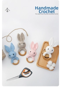 Detailed view of handmade crochet bunny rattles with natural wooden teething rings