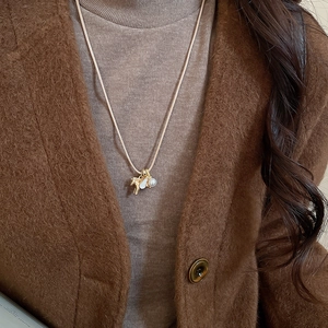 Gros plan d'un pendentif cheval avec zircon et perle sur un collier de pull chic