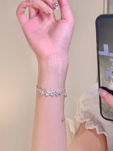 Elegant adjustable heart-shaped zircon bracelet in silver finish worn on wrist