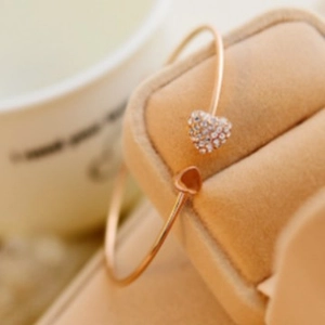 Bracciale rigido aperto a cuore oro rosa con cristalli pavé e charm a cuore liscio in scatola