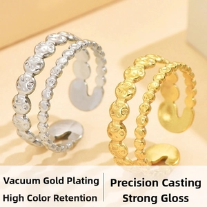 Close-up of double-row gold and silver smiley face textured adjustable open rings