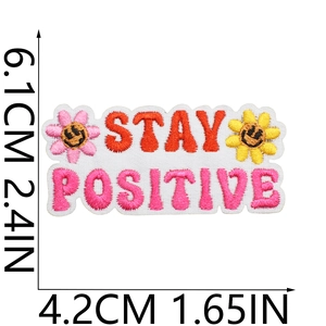 Close-up of rectangular STAY POSITIVE embroidered patch with size measurements