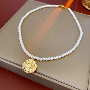 Gros plan du pendentif œil plaqué or avec pierres colorées et perles sur boîte à bijoux