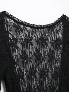 Close-up of black floral lace fabric with scalloped edges on a long dress detail