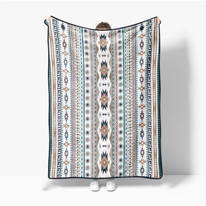 Detail of bohemian geometric flannel blanket being held up to show large size and pattern