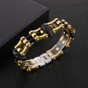 Detail of black and gold motorcycle chain bracelet with skull charm on display