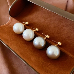 Vintage geometric faux pearl earrings with gold plating shown on dark velvet background